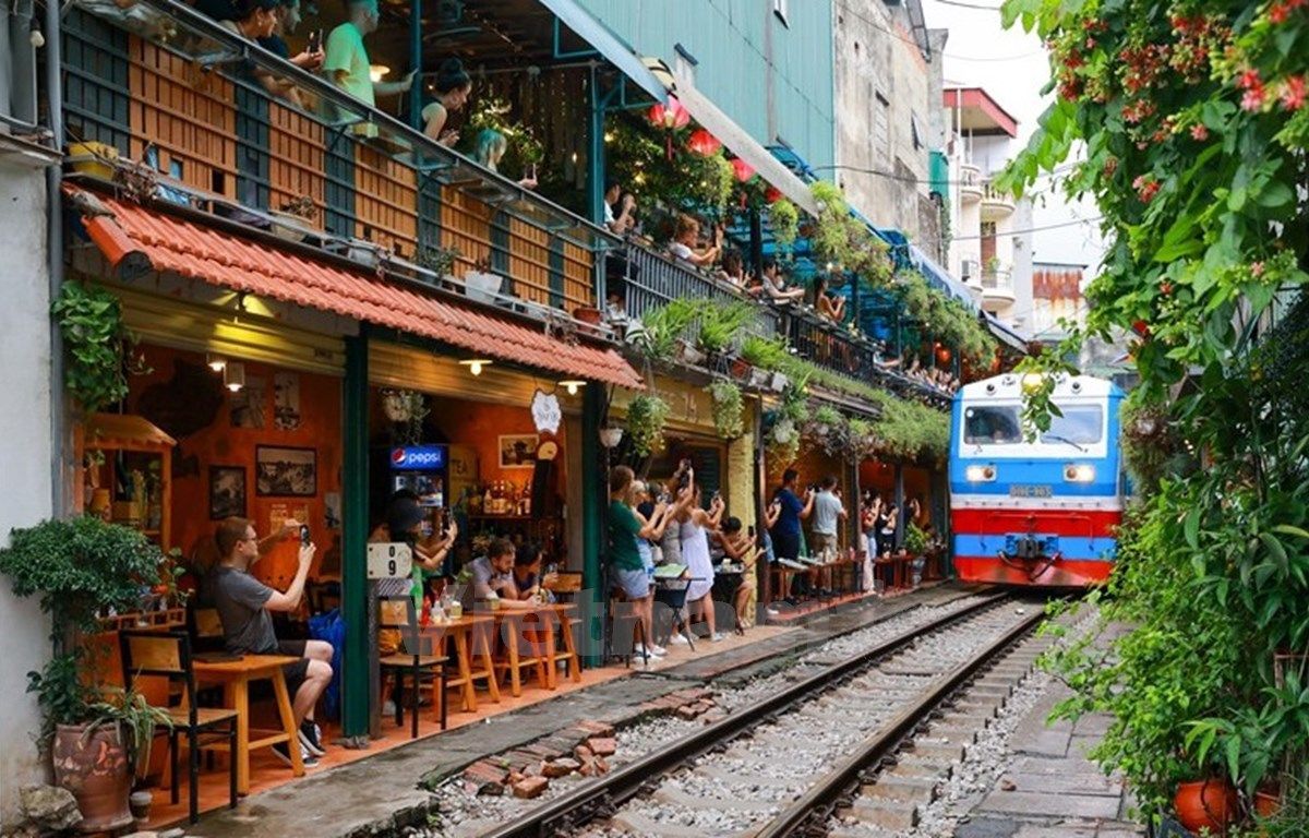 Visitors to Hanoi Train Street often enjoy sipping coffee while watching trains pass just inches away.